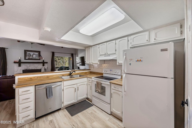 2670 Snow Slope Way, Pinetop, AZ 85935 - kitchen with white appliances, a peninsula, a sink, under cabinet range hood, and light wood-type flooring