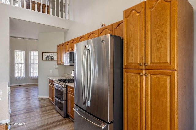 6853 Rim Rock Rd, Show Low, AZ 85901 - kitchen with stainless steel appliances, light wood-type flooring, brown cabinets, and light countertops