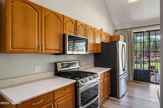 6853 Rim Rock Rd, Show Low, AZ 85901 - kitchen with appliances with stainless steel finishes, brown cabinets, light countertops, and high vaulted ceiling