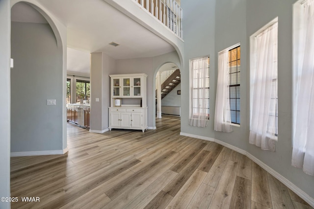 6853 Rim Rock Rd, Show Low, AZ 85901 - unfurnished living room featuring arched walkways and light wood-type flooring