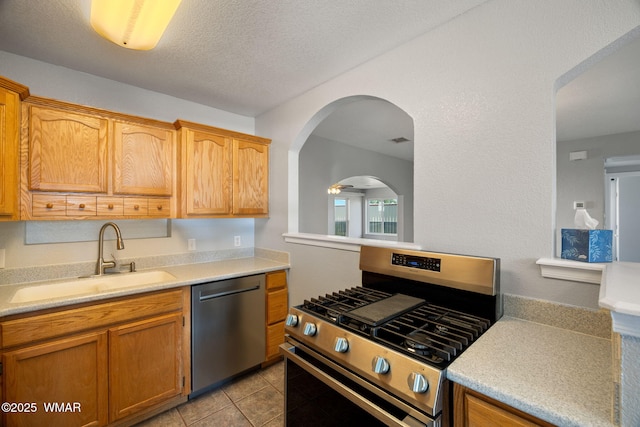 864 S 1st St E, Snowflake, AZ 85937 - kitchen featuring stainless steel appliances, a sink, light countertops, light tile patterned floors, and a textured ceiling