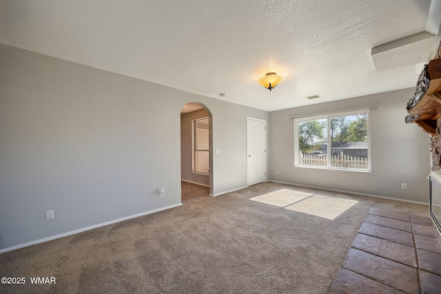 864 S 1st St E, Snowflake, AZ 85937 - carpeted empty room featuring arched walkways, baseboards, and a textured ceiling