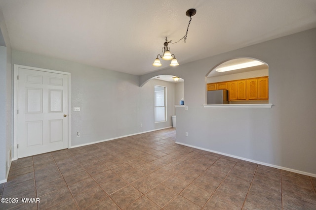 864 S 1st St E, Snowflake, AZ 85937 - unfurnished room featuring arched walkways, dark tile patterned floors, and baseboards