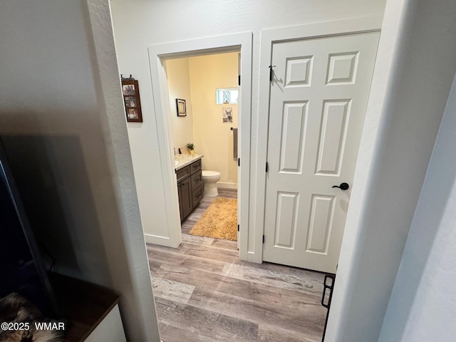 hallway featuring baseboards and light wood-type flooring