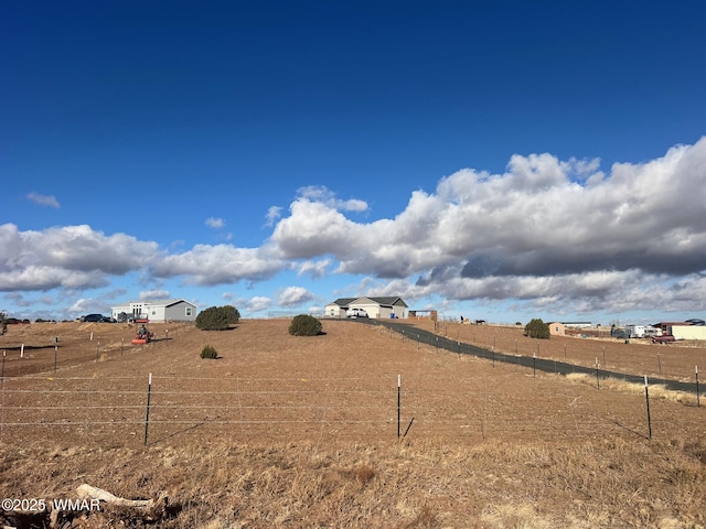 view of yard with a rural view and fence