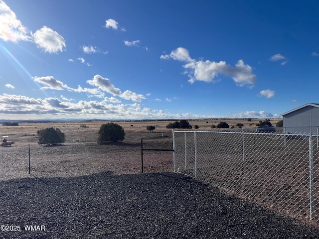 view of yard featuring a rural view and fence