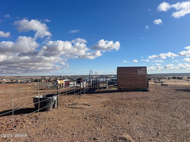 view of yard featuring an outdoor structure and a rural view