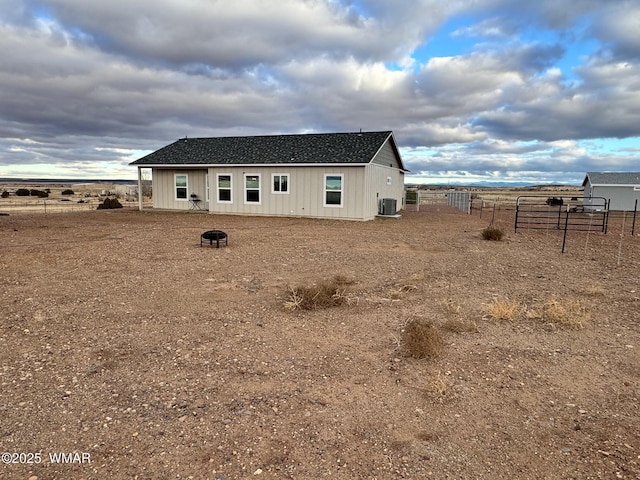 back of house featuring cooling unit, a rural view, and fence