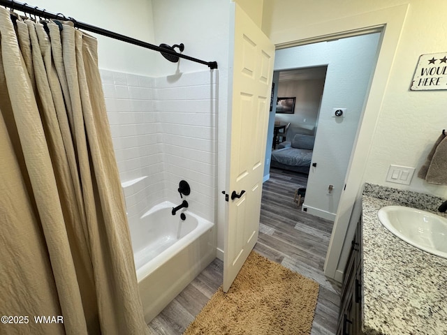 bathroom featuring vanity, wood finished floors, baseboards, shower / tub combo with curtain, and connected bathroom