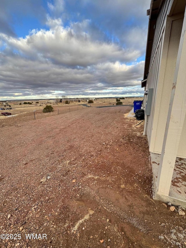 view of yard with a rural view and fence