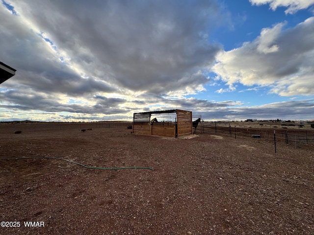 view of yard with an outbuilding, a rural view, exterior structure, and fence