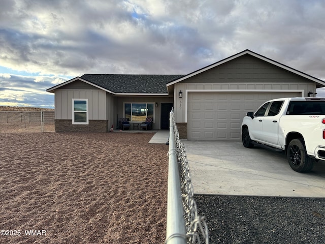 ranch-style house with fence, a shingled roof, concrete driveway, a garage, and brick siding