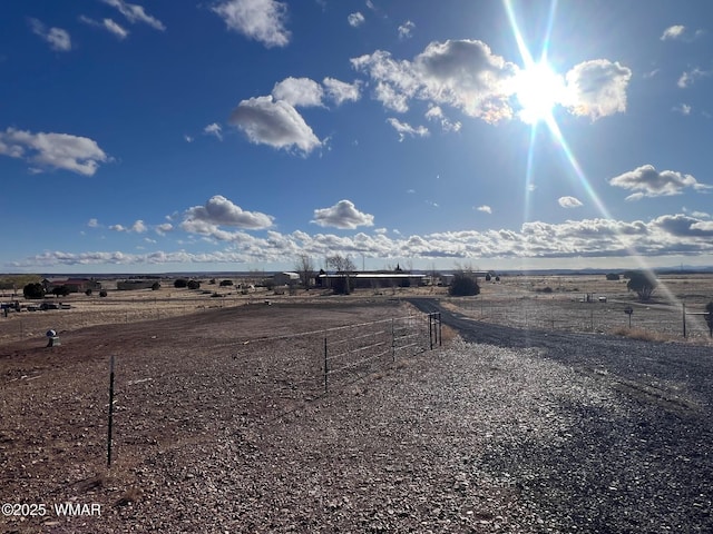 view of yard with a rural view and fence