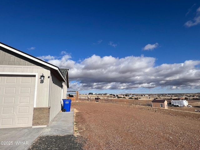 view of yard featuring a garage and fence