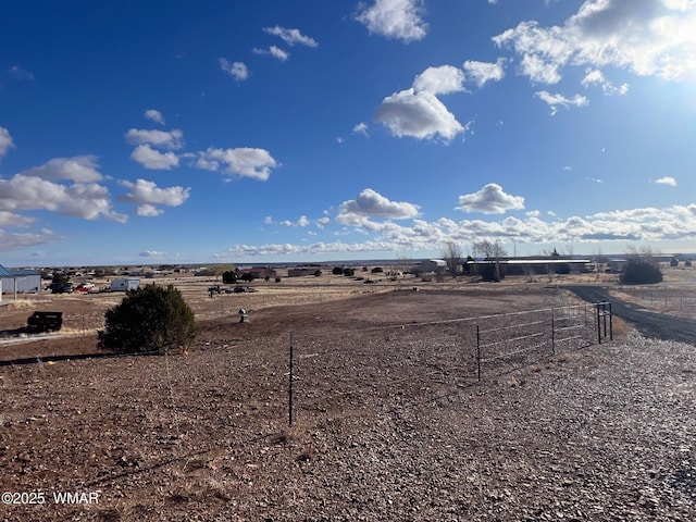 view of yard with a rural view and fence