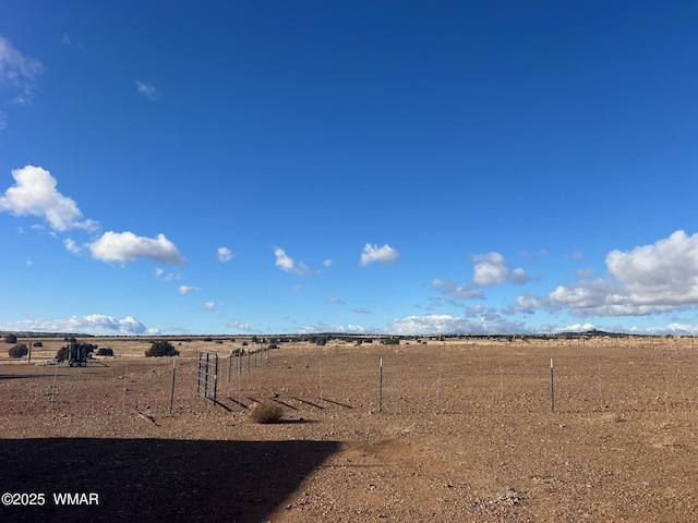 view of yard with a rural view and fence