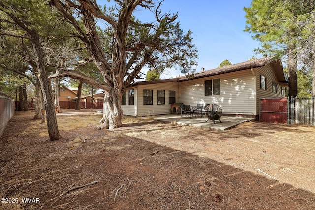 rear view of property with a fenced backyard and a patio