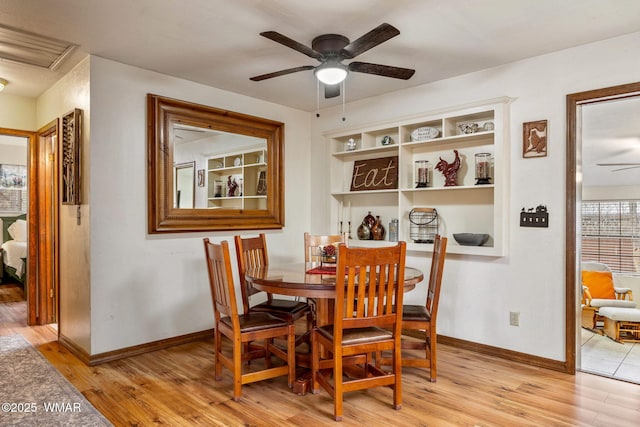 dining room with light wood finished floors, baseboards, and a ceiling fan