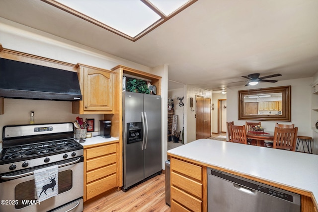 kitchen with ceiling fan, extractor fan, light countertops, appliances with stainless steel finishes, and light wood-type flooring