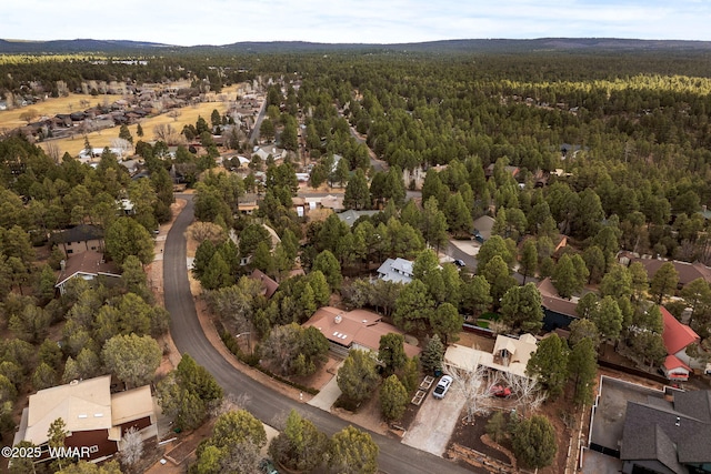 drone / aerial view featuring a residential view and a wooded view