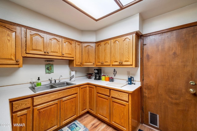 kitchen featuring brown cabinetry, light countertops, visible vents, and a sink