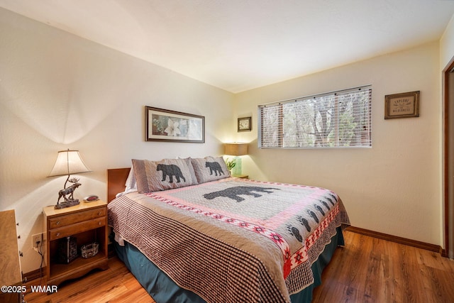 bedroom with baseboards and wood finished floors