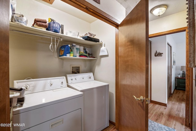 laundry area with baseboards, laundry area, light wood-style floors, and washer and dryer