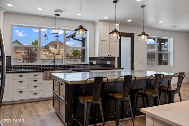 1738 W 7th St, Snowflake, AZ 85937 - kitchen featuring light wood-style flooring, a sink, a center island, backsplash, and a breakfast bar