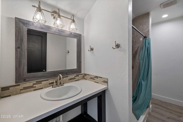 1738 W 7th St, Snowflake, AZ 85937 - bathroom with vanity, wood finished floors, tasteful backsplash, a shower with shower curtain, and baseboards