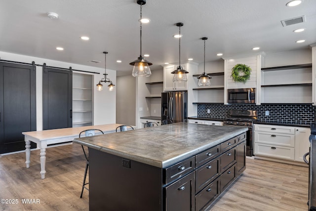 1738 W 7th St, Snowflake, AZ 85937 - kitchen with open shelves, appliances with stainless steel finishes, a breakfast bar, a kitchen island, and dark countertops