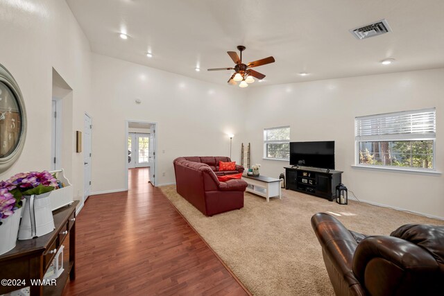 carpeted living area with baseboards, visible vents, ceiling fan, wood finished floors, and recessed lighting