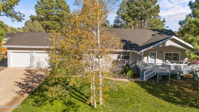 view of front of property with a porch, an attached garage, concrete driveway, roof with shingles, and a front lawn