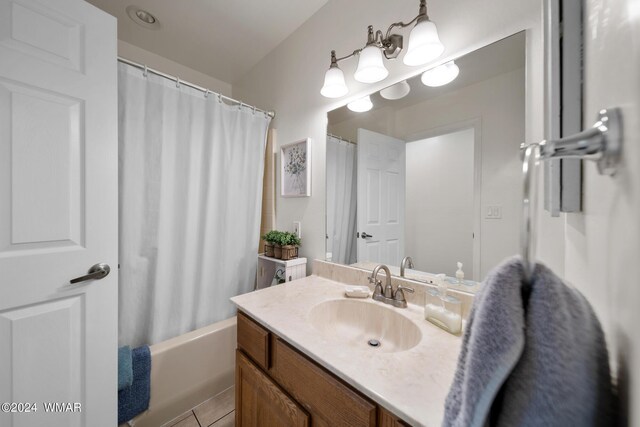 full bath featuring tile patterned floors, shower / bath combo with shower curtain, and vanity