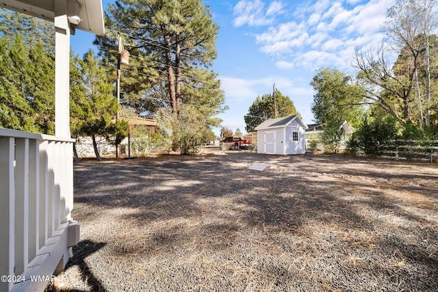 view of yard with an outbuilding, fence, and a storage unit