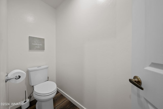 bathroom featuring toilet, baseboards, and wood finished floors