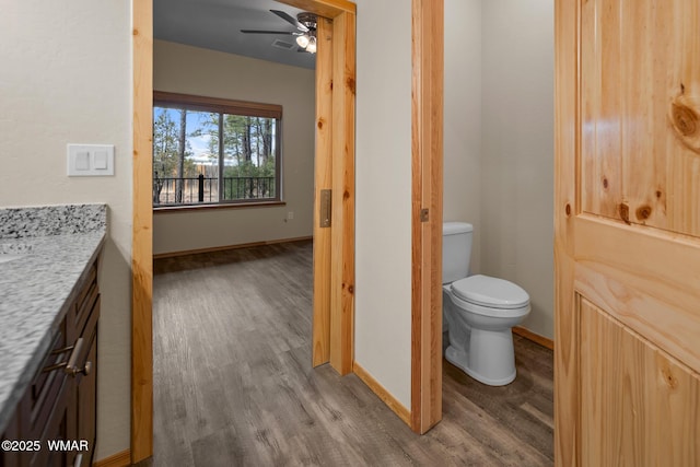 bathroom with toilet, wood finished floors, visible vents, vanity, and a ceiling fan