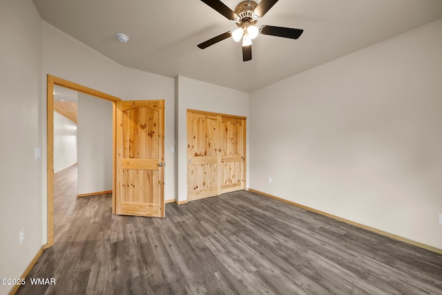 unfurnished bedroom with ceiling fan, dark wood-style flooring, and baseboards