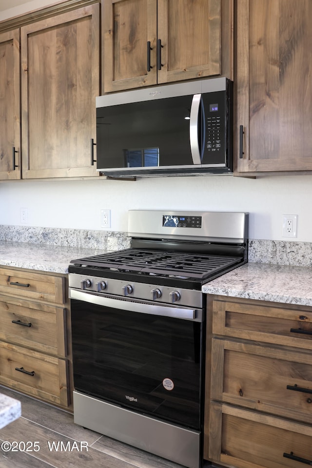 1316 W 7th St S, Snowflake, AZ 85937 - kitchen featuring appliances with stainless steel finishes, light stone counters, brown cabinetry, and wood finished floors