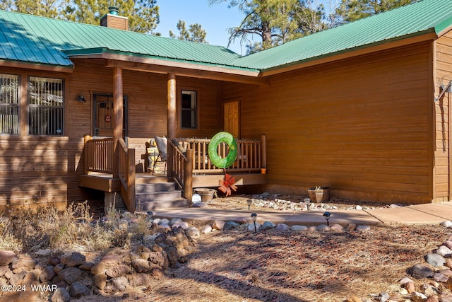 2740 W Maple Ln, Show Low, AZ 85901 - doorway to property featuring a porch, a chimney, and metal roof