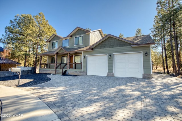 view of front facade with a porch, decorative driveway, and an attached garage