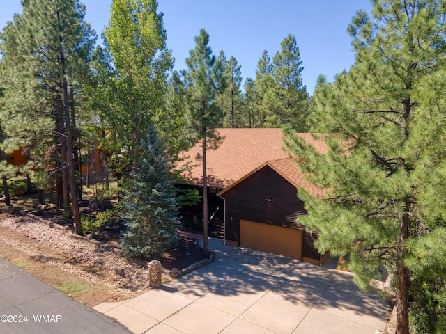 rustic home featuring a garage and concrete driveway