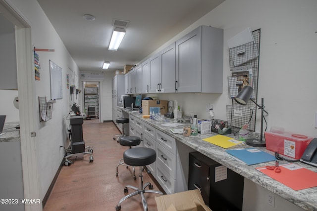 kitchen with light wood-type flooring and light stone countertops