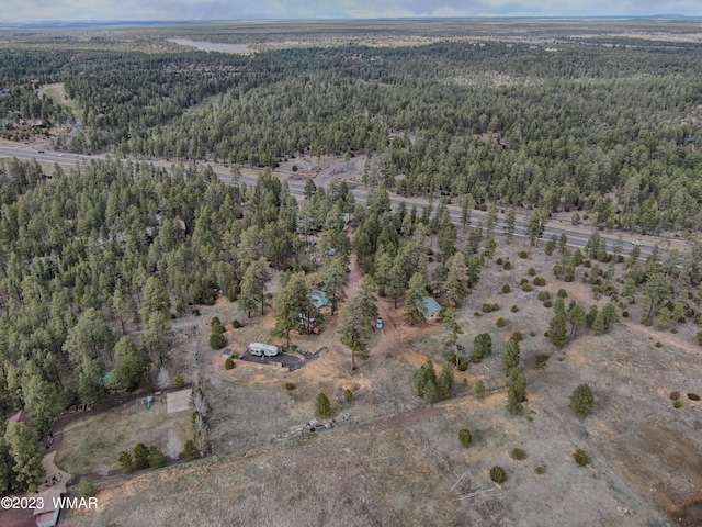 drone / aerial view featuring a wooded view