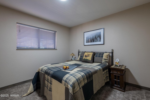 bedroom featuring dark colored carpet and baseboards