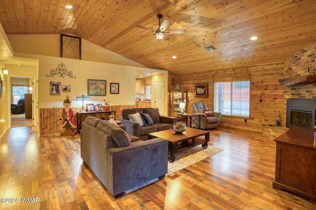 living room with a fireplace, wooden ceiling, wood finished floors, and visible vents