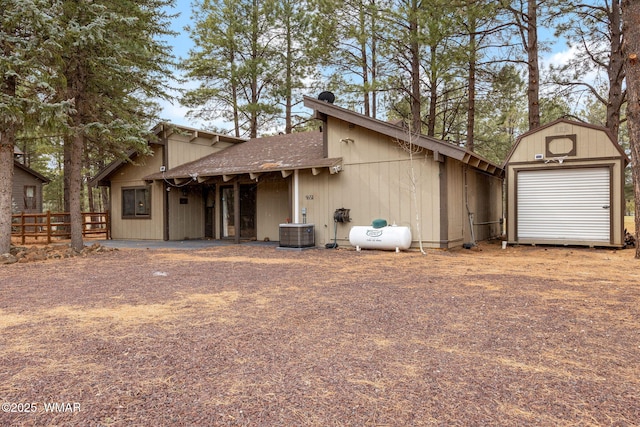 exterior space featuring an outbuilding, a detached garage, central AC unit, fence, and a shed