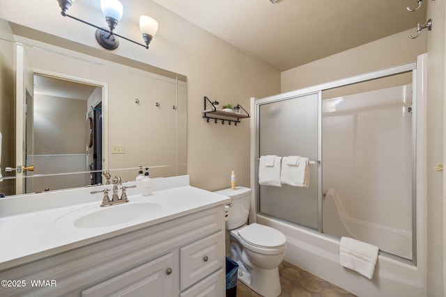 bathroom featuring toilet, vanity, and enclosed tub / shower combo