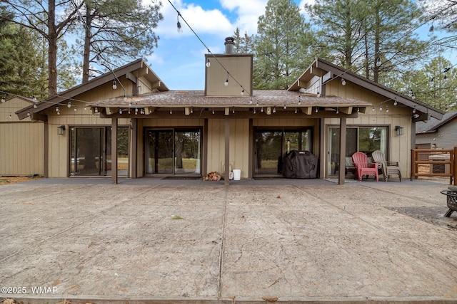 rear view of property with a chimney and a patio area