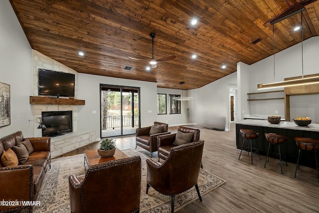 living room featuring high vaulted ceiling, a stone fireplace, visible vents, wood ceiling, and light wood-type flooring