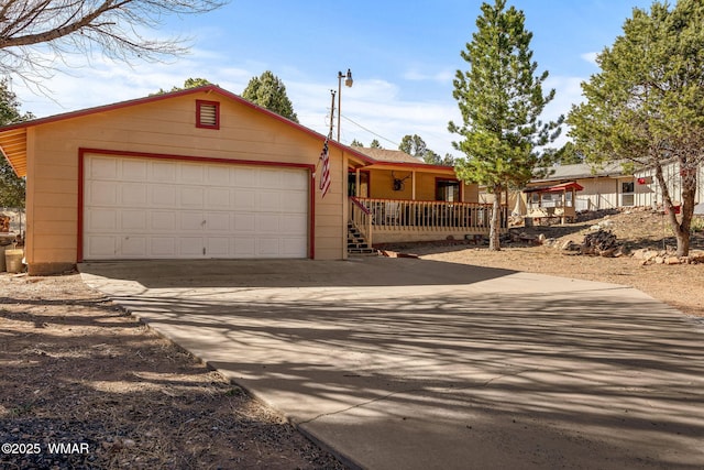 ranch-style home with an attached garage, covered porch, and concrete driveway